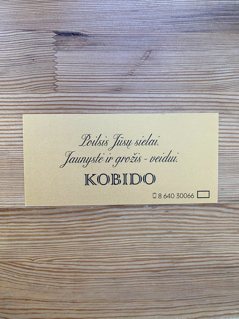 KOBIDO veido masažo dovanų kuponas ant medinio stalo